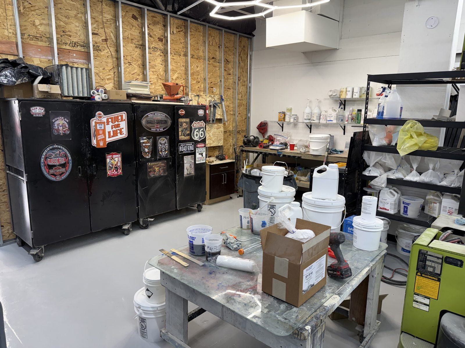 ATC Supply sample studio featuring a mixing table with test pours, pigment and additive storage shelves, and a full pail wall for contractors to test products